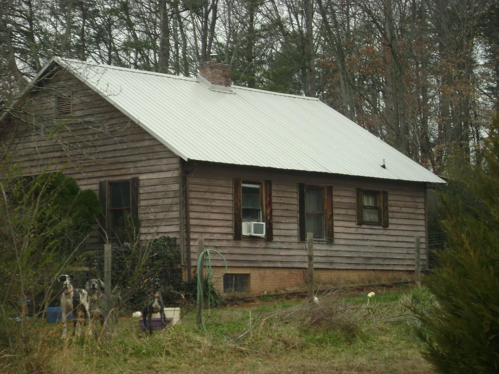 White metal roof on an old wood sided farmhouse, from a Metal Roof Installation job in Dalton